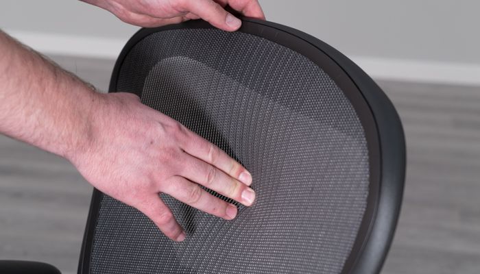 Pushing into the mesh upholstery
